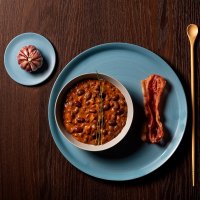 Fagioli messicani, con fetta di bacon croccante e testa d'aglio decorativa