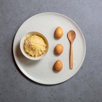 Patate in tecia con decorazione di patate intere e mestolo in legno