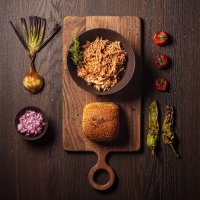 Pulled pork con decorazioni di verdure caramellate: cipolla, pomodorini, peperoni verdi e pane