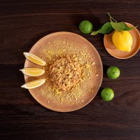 Pulle di pollo agli agrumi con decorazione di fette di limone, limone intero e lime